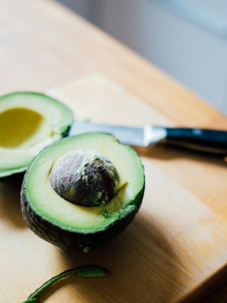 slice of avocado fruit on brown wooden board
