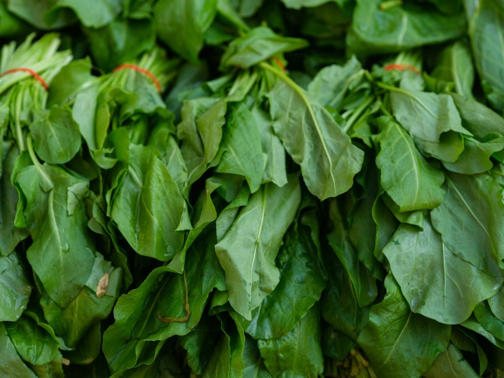 a pile of green leafy vegetables sitting on top of a table