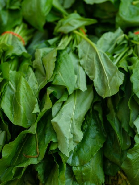 a pile of green leafy vegetables sitting on top of a table